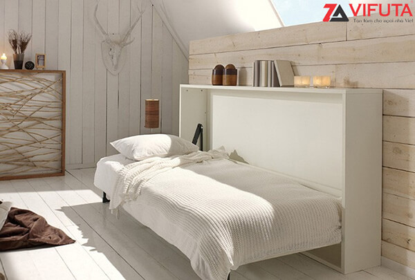 Nóc của giường gắn gấp tường được tận dụng để bày sách vở, nến thơm hoặc đồ trang trí